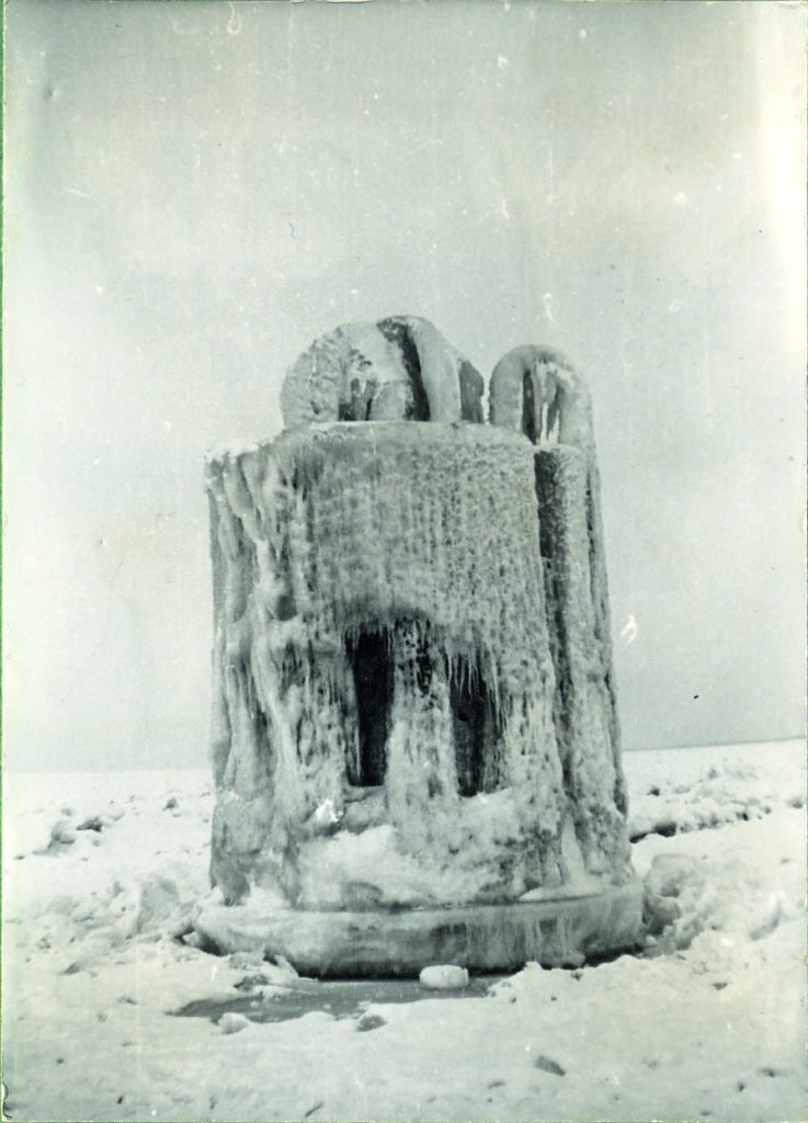 Zdjęcie czarno-białe przedstawiające tzw. betonową beczkę pokrytą lodem i soplami.